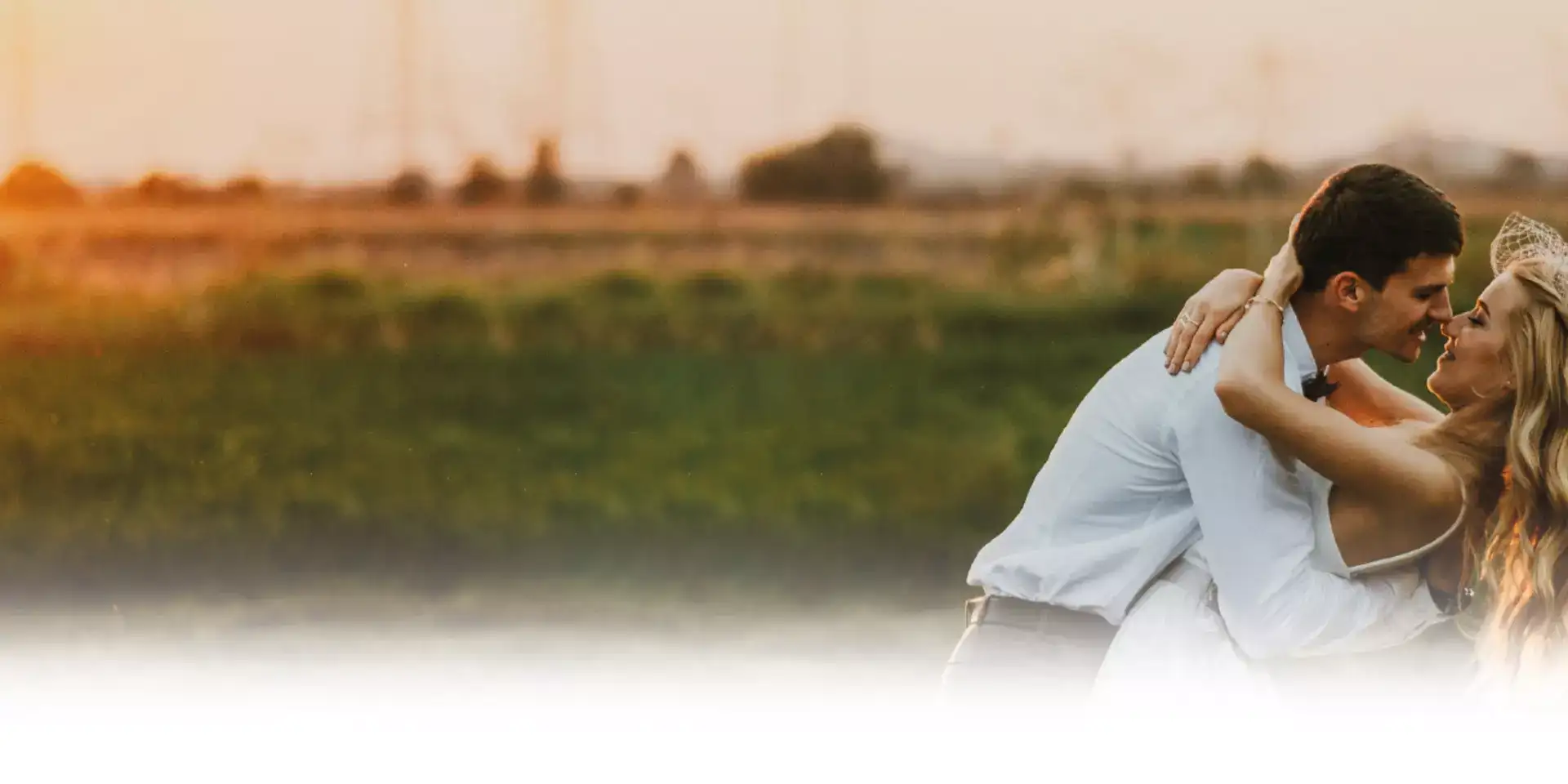 Hochzeitsmesse Header: Brautpaar umarmt sich innig, romantische Hochzeit im Freien.