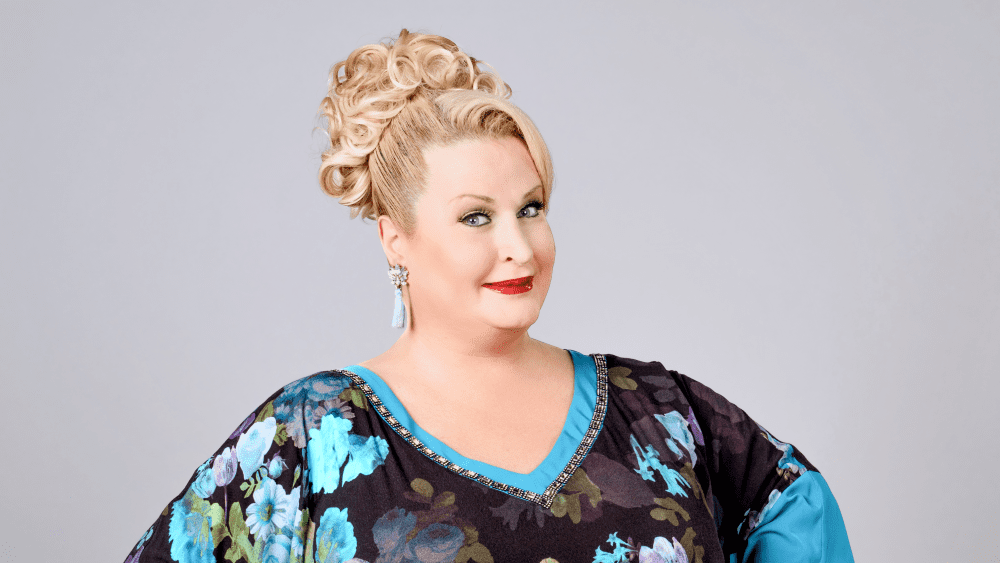 2027_04_02 Daphne_BeiallerLiebe_Foto_AnnikaFußwinkel_Banner_1000px Daphne de Luxe, Porträt. Blond, floral gemustertes Oberteil. BeiallerLiebe.