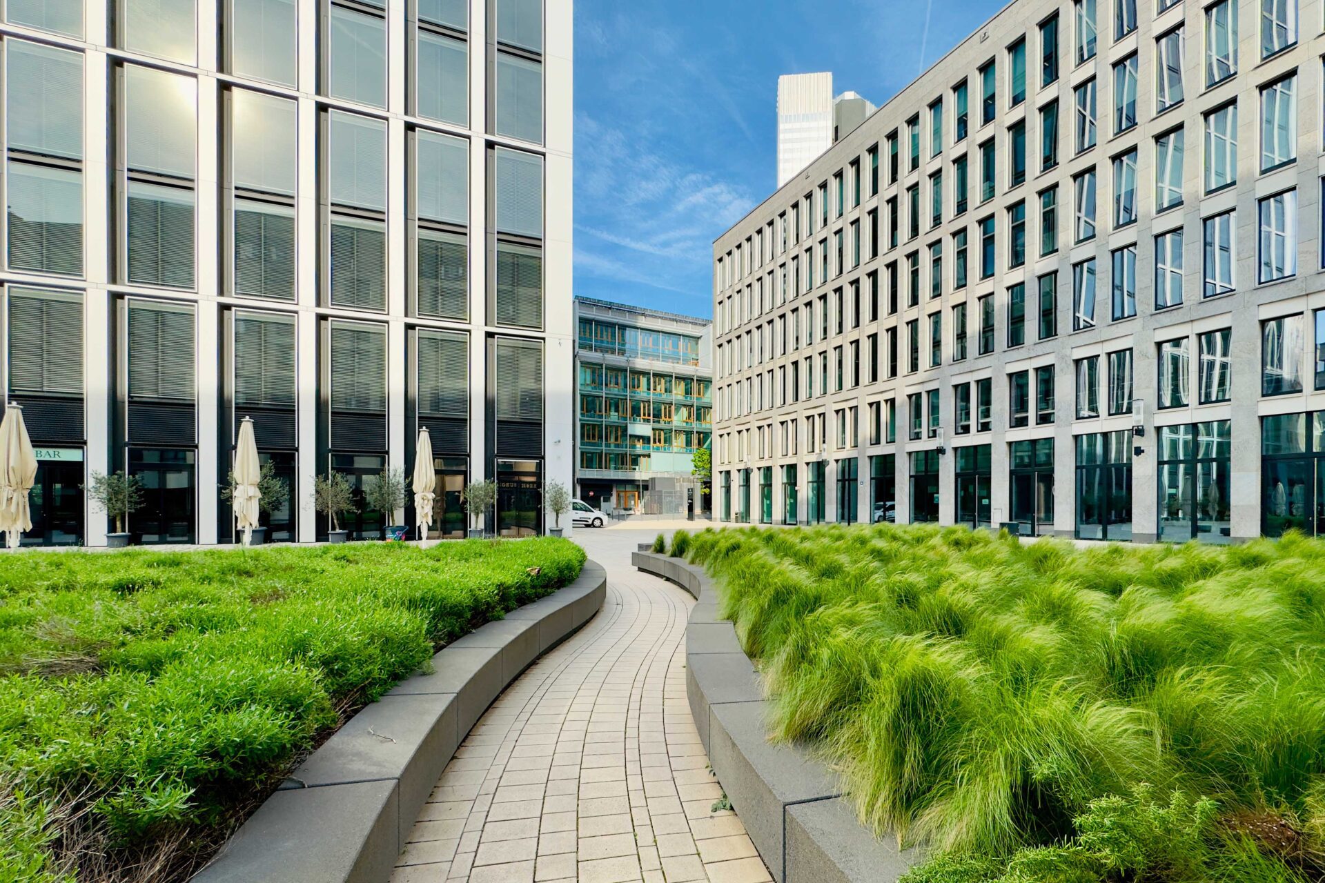 Moderne Architektur mit Grünflächen für Bauinnovation- und Brandschutztag 2025. Kiwa Einladung.
