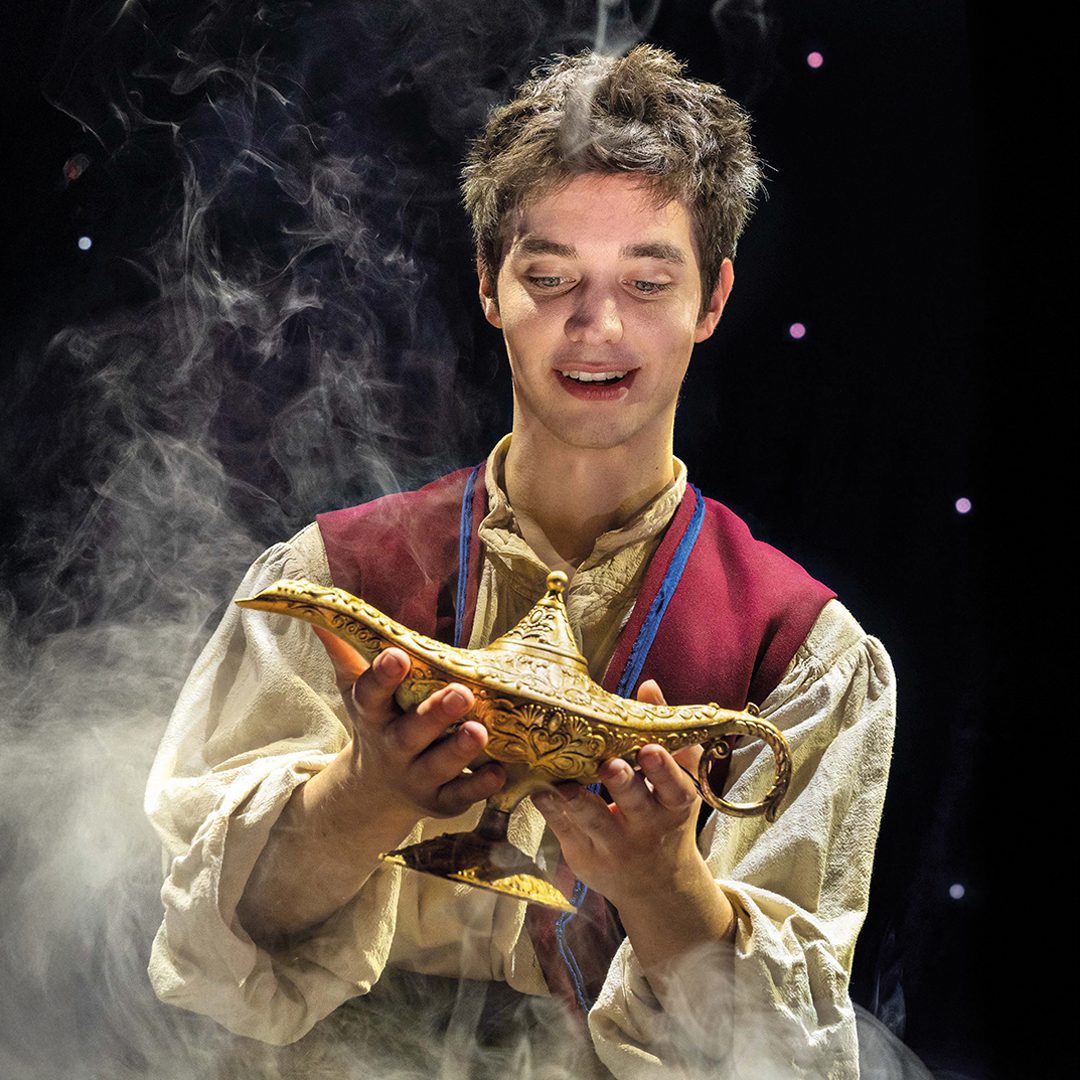 aladin-musical-motiv-2-quadrat-1080x1080px-theater-liberi-nilz-boehme Aladin Musical Motiv: Mann hält goldene Lampe, aus der Rauch aufsteigt.